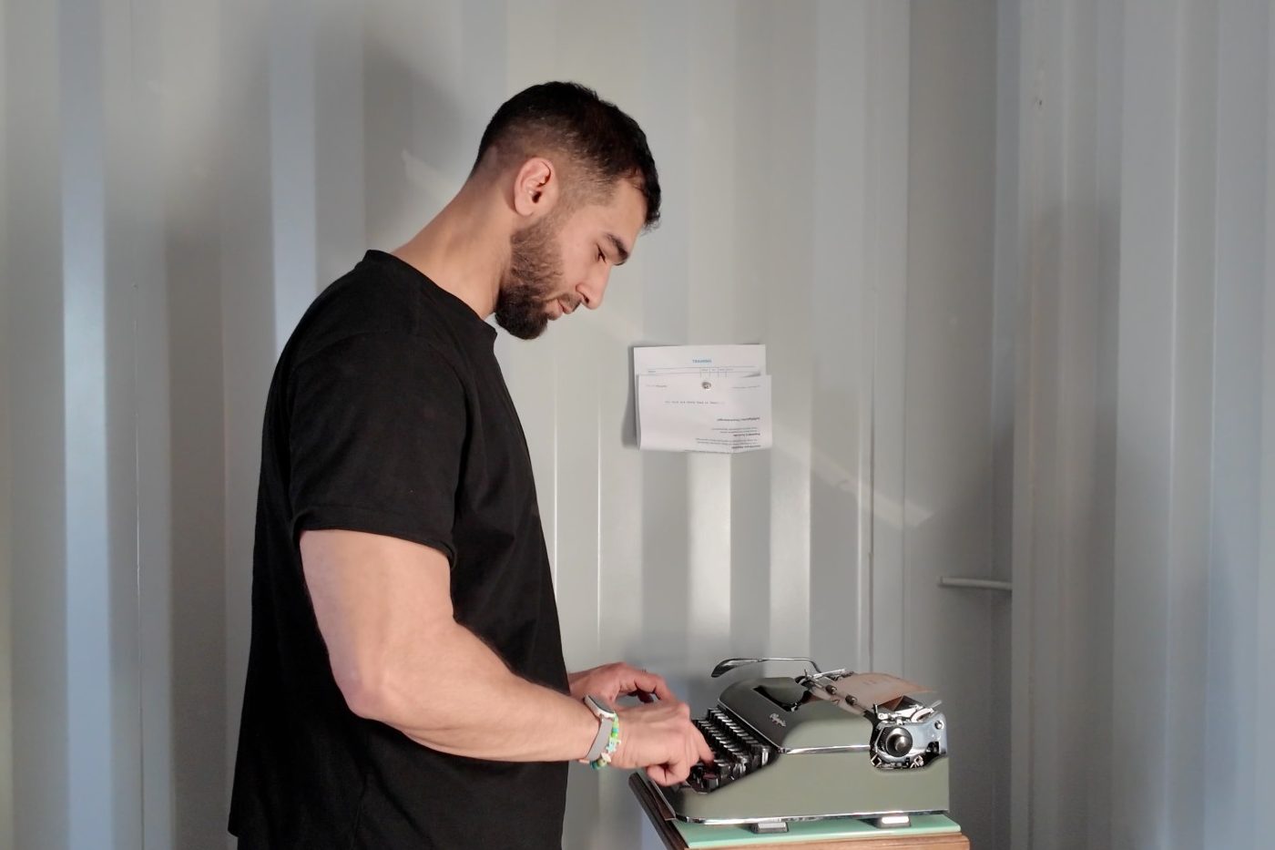 Coach Izzy tippt an einer alten Schreibmaschine im Base33
